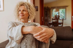 Middle-aged woman sitting calmly, conveying well-being and positivity, symbolizing effective management of lichen sclerosus.